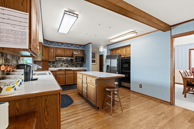 46890 Cider Mill Dr, Novi, MI 48374 - kitchen featuring appliances with stainless steel finishes, light wood-type flooring, a kitchen island, brown cabinetry, and a breakfast bar area
