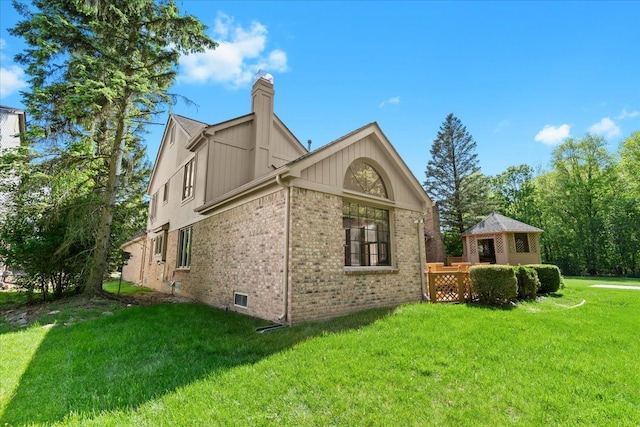 46890 Cider Mill Dr, Novi, MI 48374 - view of home's exterior featuring brick siding, a yard, a chimney, and a gazebo