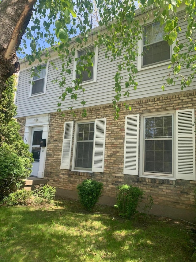 view of front facade featuring brick siding and a front yard