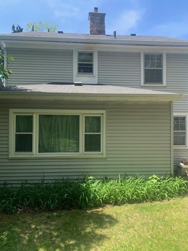 back of house featuring a chimney