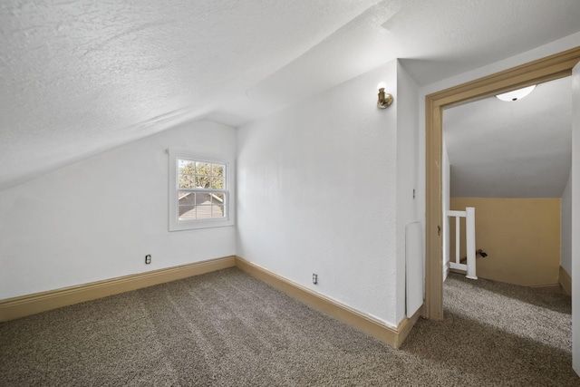 1702 Teneyck St, Jackson, MI 49203 - additional living space with vaulted ceiling, carpet flooring, a textured ceiling, and baseboards