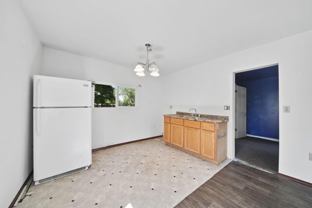 1702 Teneyck St, Jackson, MI 49203 - kitchen with freestanding refrigerator, a chandelier, a sink, and baseboards