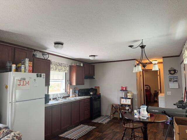 kitchen with freestanding refrigerator, black range with electric cooktop, a sink, a textured ceiling, and dark wood-style floors
