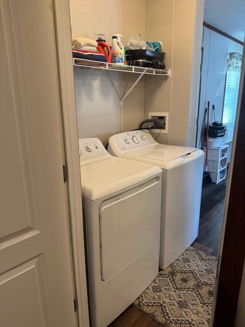 laundry room with washer and clothes dryer and wood finished floors