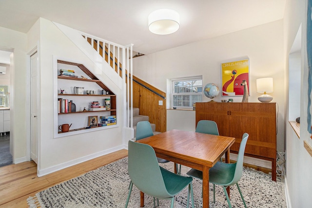 371 4th St, Pentwater, MI 49449 - dining space with stairway, light wood finished floors, and baseboards