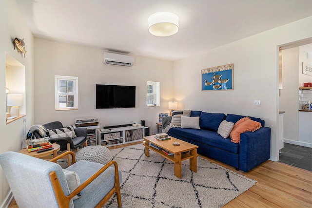 371 4th St, Pentwater, MI 49449 - living room featuring an AC wall unit, wood finished floors, and healthy amount of natural light