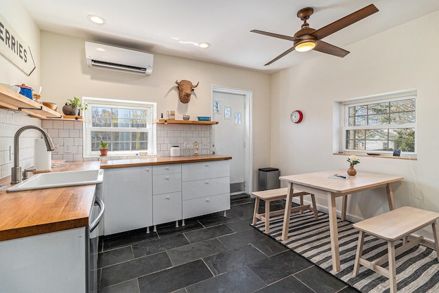 371 4th St, Pentwater, MI 49449 - kitchen featuring butcher block counters, a wall mounted air conditioner, open shelves, a sink, and recessed lighting