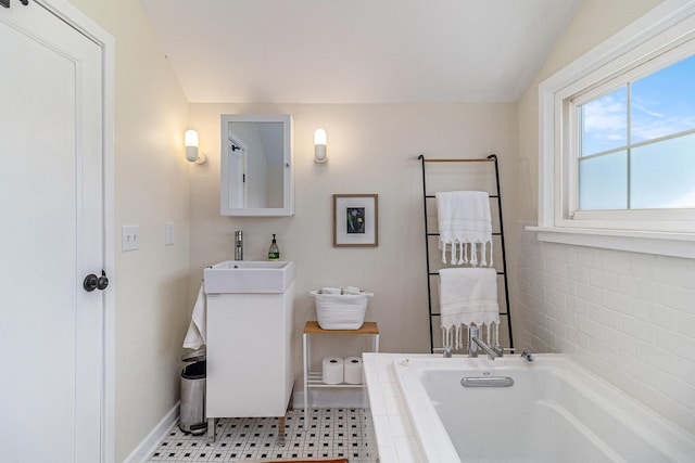 371 4th St, Pentwater, MI 49449 - bathroom with a garden tub, baseboards, and vanity