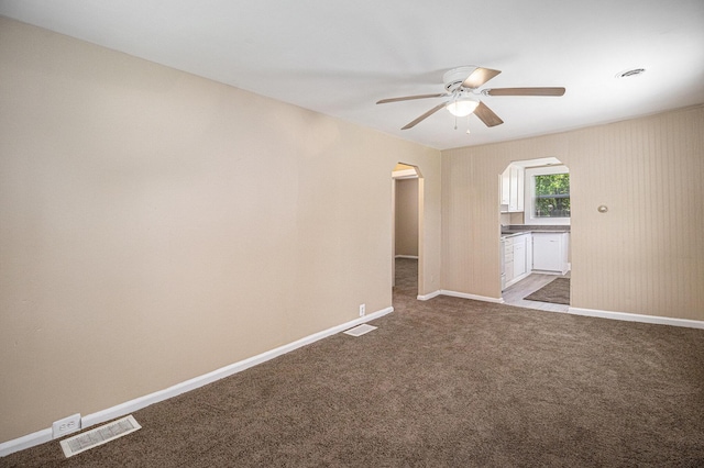 2335 Holmes Rd, Ypsilanti, MI 48198 - carpeted empty room with arched walkways, a ceiling fan, and baseboards