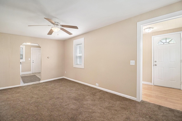 2335 Holmes Rd, Ypsilanti, MI 48198 - unfurnished room featuring arched walkways, carpet, a ceiling fan, and plenty of natural light