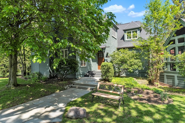 2462 N Dixboro Rd, Ann Arbor, MI 48105 - view of property hidden behind natural elements featuring a front yard and a shingled roof