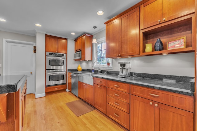 2462 N Dixboro Rd, Ann Arbor, MI 48105 - kitchen featuring crown molding, stainless steel appliances, a sink, light wood-style flooring, and brown cabinets