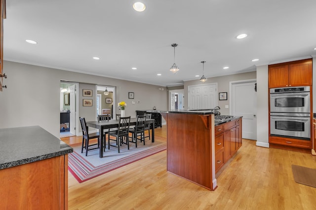 2462 N Dixboro Rd, Ann Arbor, MI 48105 - kitchen with stainless steel double oven, light wood-style floors, recessed lighting, ornamental molding, and hanging light fixtures