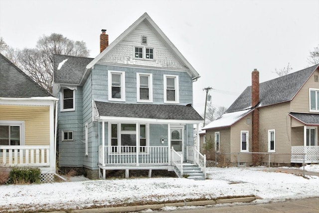 view of front of home featuring a porch, roof with shingles, and a chimney