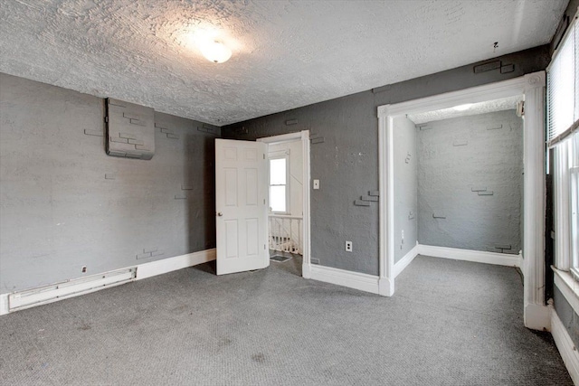 unfurnished bedroom with carpet floors, a textured ceiling, and baseboards