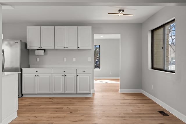 29244 Marshall St, Southfield, MI 48076 - kitchen featuring freestanding refrigerator, white cabinetry, and light wood-type flooring