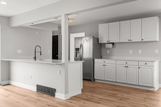 29244 Marshall St, Southfield, MI 48076 - kitchen with stainless steel fridge, a sink, white cabinetry, light wood-type flooring, and a peninsula