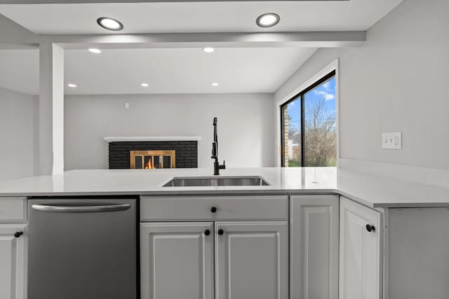 29244 Marshall St, Southfield, MI 48076 - kitchen with stainless steel dishwasher, a sink, white cabinets, recessed lighting, and a brick fireplace