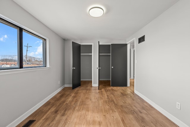 29244 Marshall St, Southfield, MI 48076 - unfurnished bedroom with two closets, wood finished floors, and baseboards