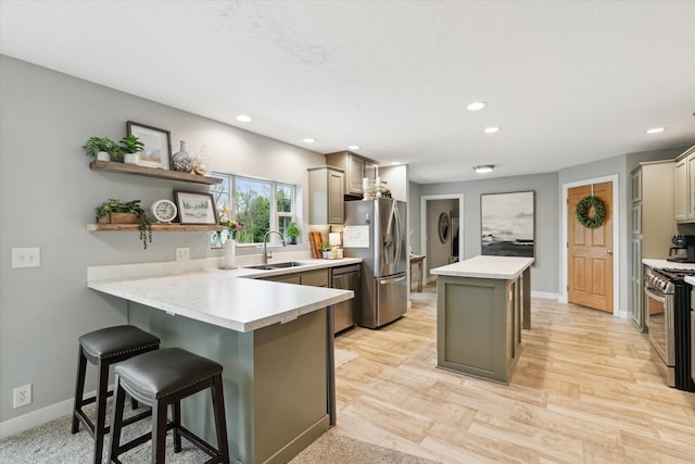 75349 12th Ave, South Haven, MI 49090 - kitchen with appliances with stainless steel finishes, a sink, a center island, a peninsula, and light countertops