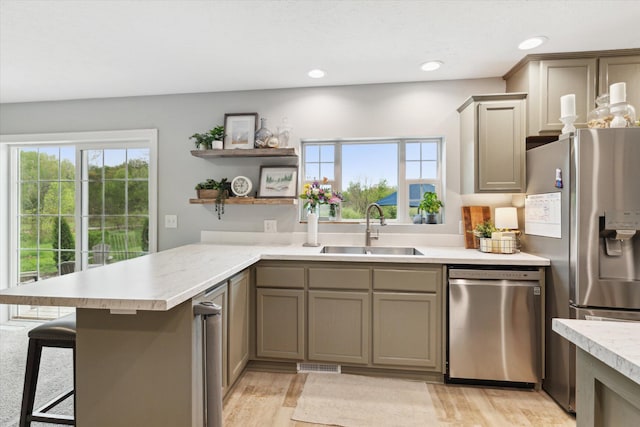 75349 12th Ave, South Haven, MI 49090 - kitchen with stainless steel appliances, a sink, light countertops, a breakfast bar, and a peninsula