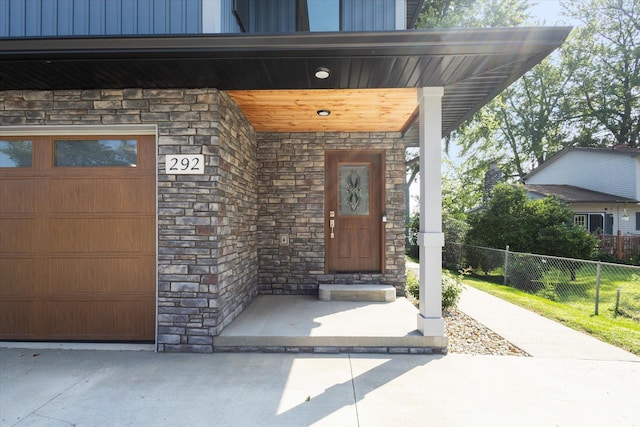 292 Lyon Lake Rd, Marshall, MI 49068 - view of exterior entry with stone siding, fence, and covered porch