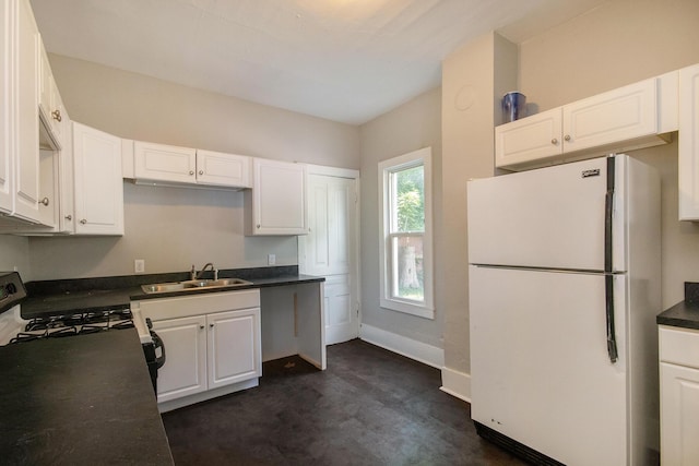 811 Park St SW, Grand Rapids, MI 49504 - kitchen featuring freestanding refrigerator, a sink, dark countertops, and white cabinetry