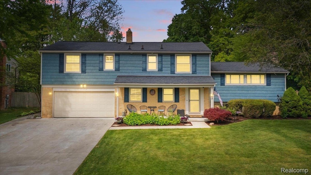 26347 Greythorne Trl, Farmington Hills, MI 48334 - view of front facade with an attached garage, covered porch, a chimney, and driveway