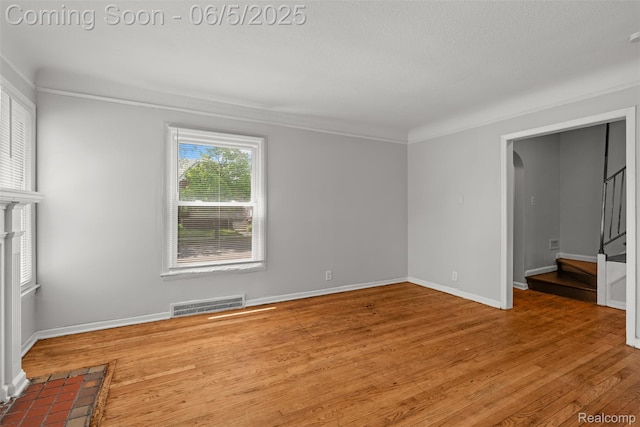 15285 Hazelridge St, Detroit, MI 48205 - spare room with stairway, wood finished floors, crown molding, baseboards, and arched walkways