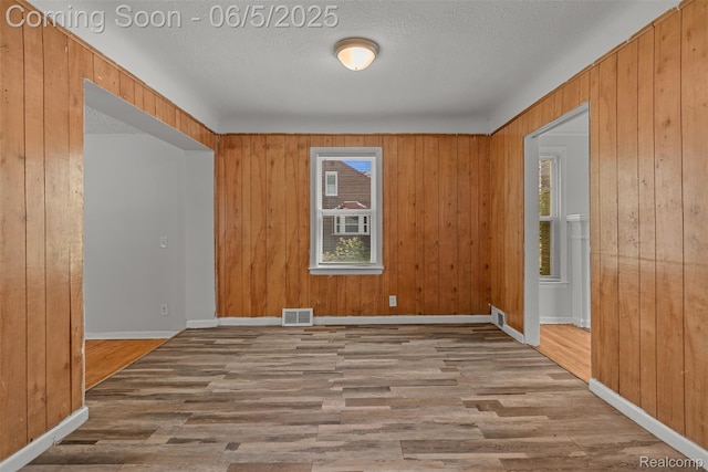 15285 Hazelridge St, Detroit, MI 48205 - spare room featuring wood finished floors, wood walls, baseboards, and a textured ceiling