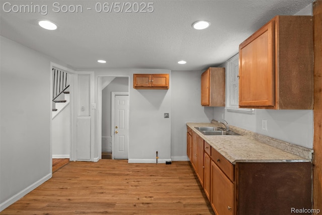 15285 Hazelridge St, Detroit, MI 48205 - kitchen with a sink, light wood-style floors, baseboards, light countertops, and brown cabinets