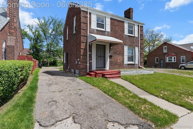 15285 Hazelridge St, Detroit, MI 48205 - view of front of house with a chimney, brick siding, and a front yard