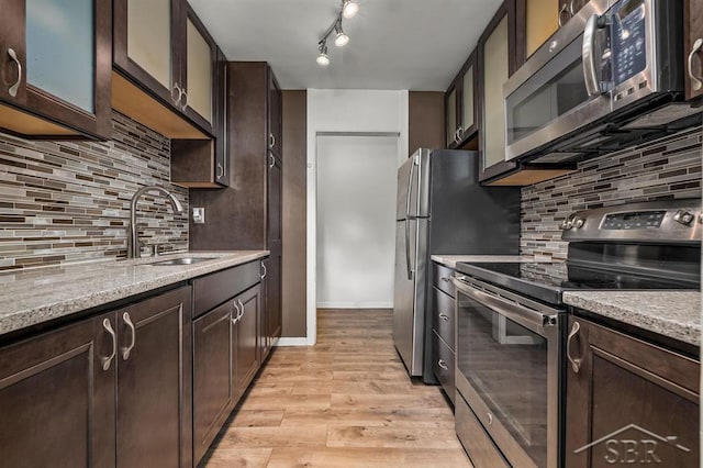 2119 Bayliss St, Midland, MI 48640 - kitchen with appliances with stainless steel finishes, a sink, dark brown cabinetry, and decorative backsplash
