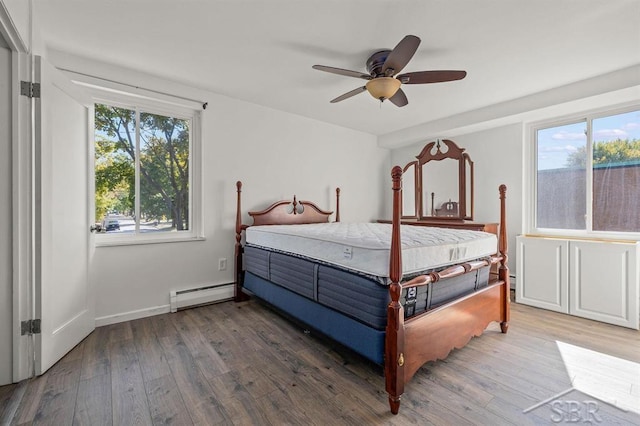 2119 Bayliss St, Midland, MI 48640 - bedroom with baseboard heating, wood finished floors, multiple windows, and a ceiling fan