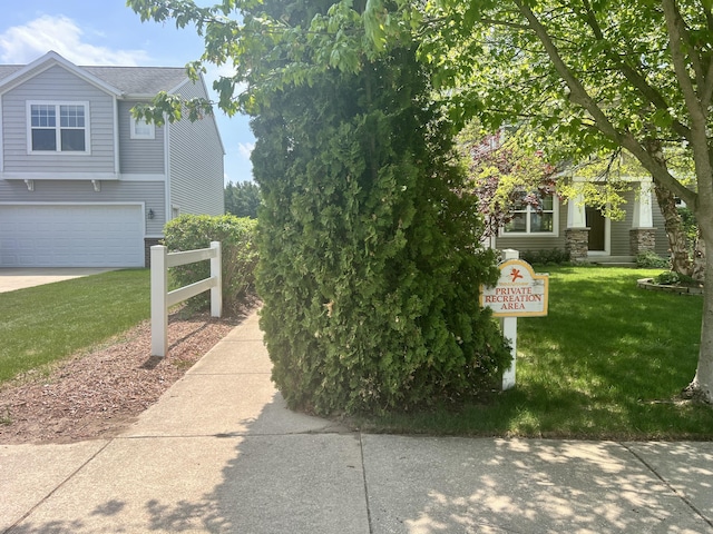 1579 Red Stem Dr, Holland, MI 49424 - view of side of home featuring a yard, a garage, and concrete driveway