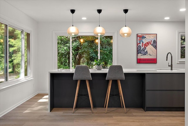 7044 Cascade Rd SE, Grand Rapids, MI 49546 - kitchen featuring light countertops, healthy amount of natural light, hanging light fixtures, recessed lighting, and light wood-type flooring