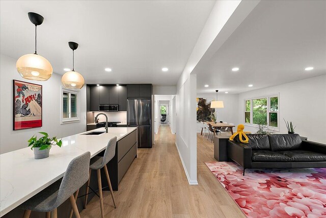 7044 Cascade Rd SE, Grand Rapids, MI 49546 - kitchen featuring appliances with stainless steel finishes, light wood-type flooring, light countertops, modern cabinets, and recessed lighting