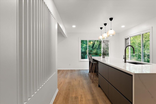 7044 Cascade Rd SE, Grand Rapids, MI 49546 - kitchen featuring light wood finished floors, recessed lighting, decorative light fixtures, modern cabinets, and a center island with sink