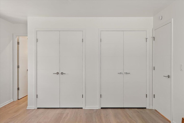 7044 Cascade Rd SE, Grand Rapids, MI 49546 - unfurnished bedroom with multiple closets and light wood-type flooring