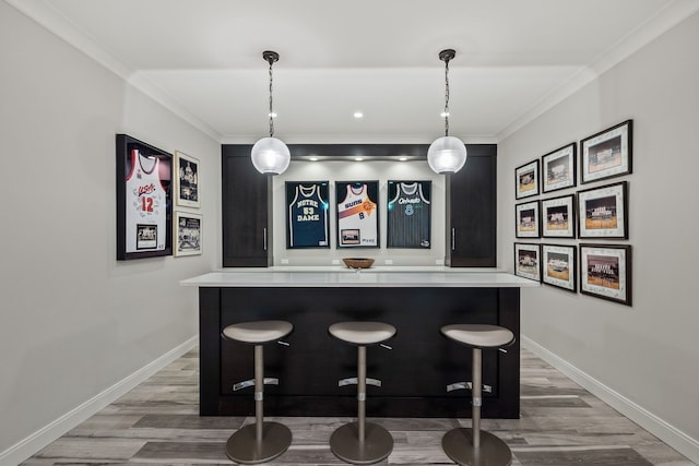 628 Watkins St, Birmingham, MI 48009 - indoor dry bar featuring light wood-style flooring, crown molding, baseboards, and pendant lighting