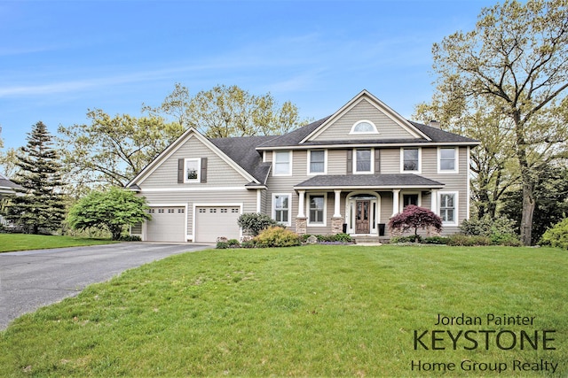 view of front facade featuring driveway, an attached garage, a front lawn, a shingled roof, and a porch