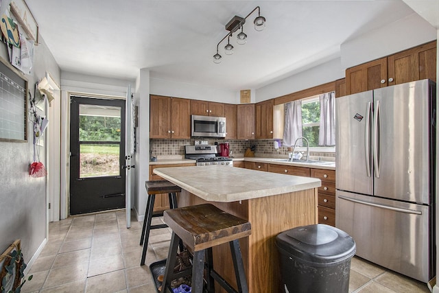 23431 Shurte St, Cassopolis, MI 49031 - kitchen with appliances with stainless steel finishes, light countertops, a sink, tasteful backsplash, and a kitchen island