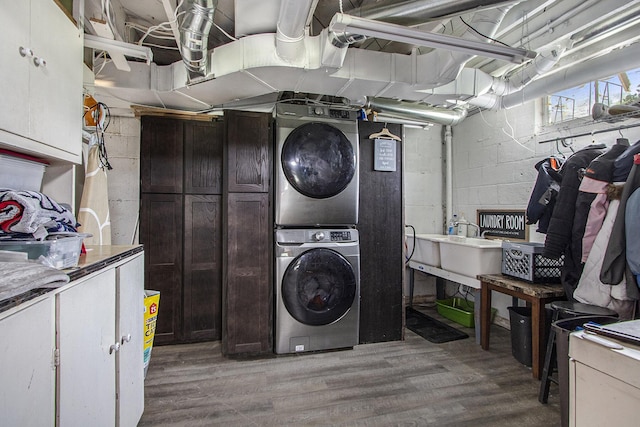 23431 Shurte St, Cassopolis, MI 49031 - washroom featuring stacked washer and clothes dryer, cabinet space, light wood finished floors, and concrete block wall
