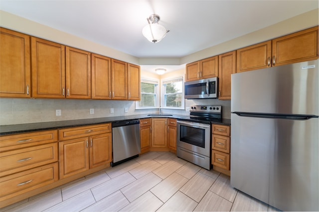 14560 Arden St, Livonia, MI 48154 - kitchen with appliances with stainless steel finishes, brown cabinetry, dark countertops, and backsplash