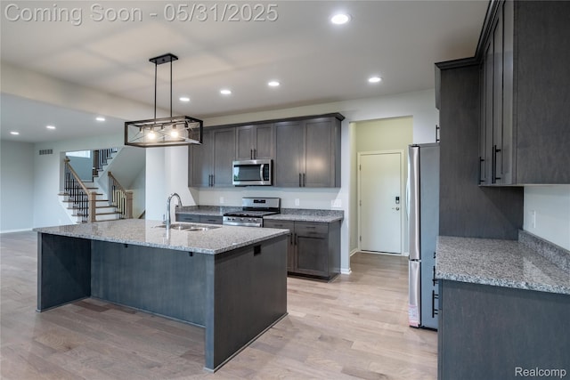 24180 Liberty Hill Dr, Farmington, MI 48336 - kitchen with appliances with stainless steel finishes, a sink, light stone counters, light wood-type flooring, and recessed lighting