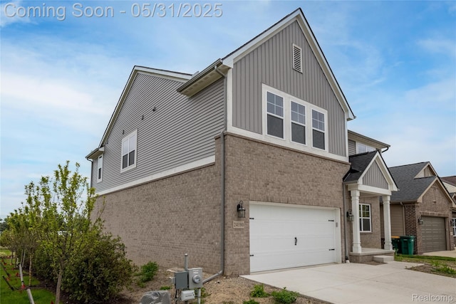24180 Liberty Hill Dr, Farmington, MI 48336 - view of side of property with brick siding, concrete driveway, a garage, and board and batten siding