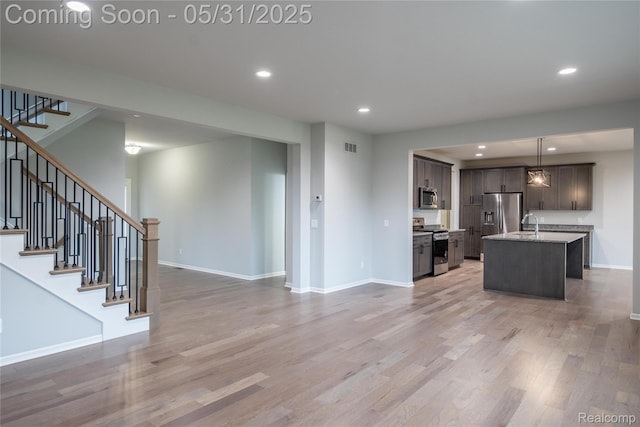 24180 Liberty Hill Dr, Farmington, MI 48336 - kitchen with appliances with stainless steel finishes, open floor plan, a kitchen island with sink, baseboards, and recessed lighting