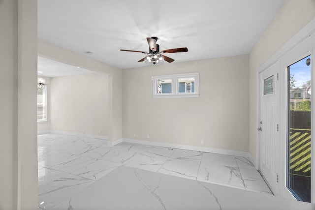 spare room featuring baseboards, marble finish floors, and a ceiling fan
