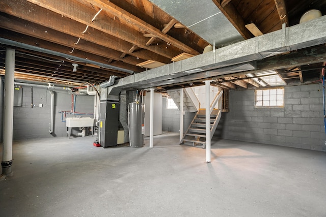 below grade area with electric water heater, stairs, heating unit, and a sink