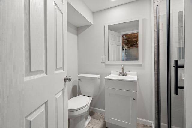 full bathroom featuring toilet, vanity, baseboards, and a tile shower